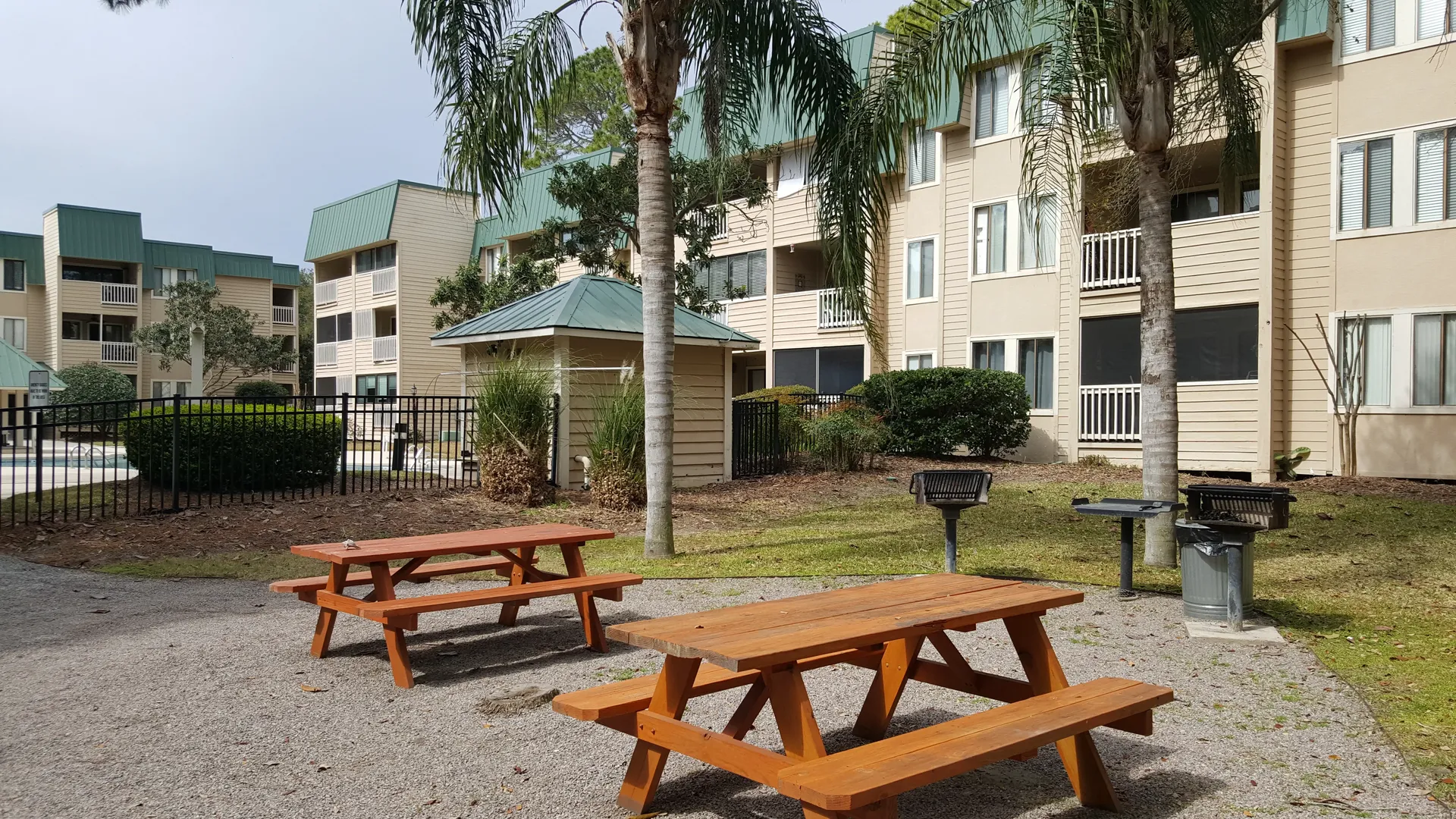 Picnic tables and charcoal grills between buildings